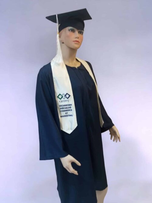 Un mannequin de Toge Standard est vêtu d'une robe de remise de diplôme bleu foncé et d'une casquette avec un pompon blanc. Le mannequin porte également une étole blanche ornée de texte et de logos bleus, représentant probablement un programme ou une institution universitaire. Le fond est uni et de couleur claire.